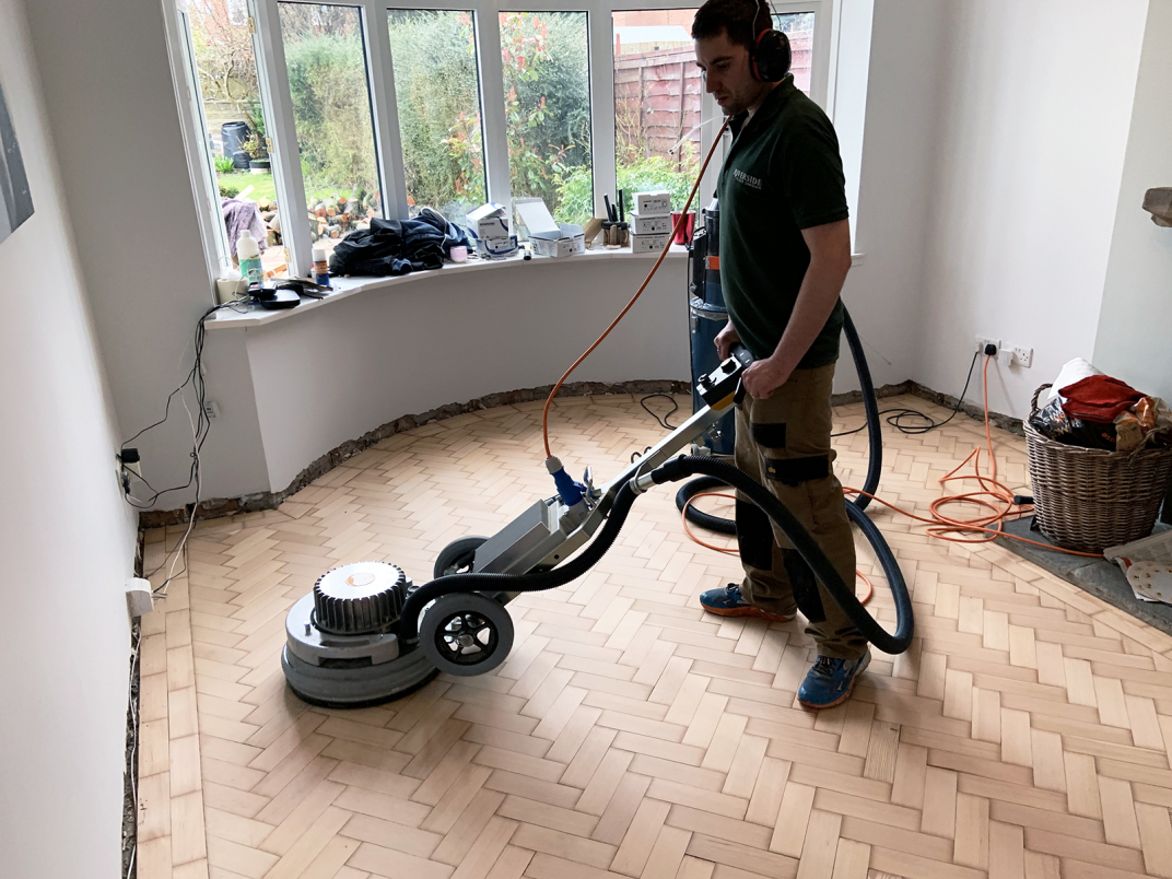 Team member Tom sands a parquet floor using the Pallmann Spider